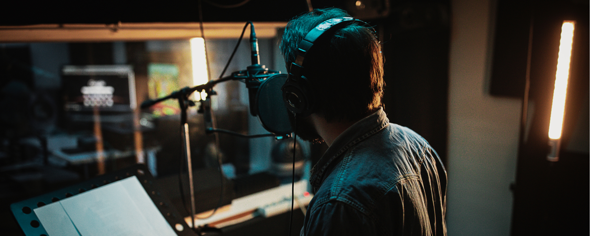Male singer singing into a recording studio microphone.