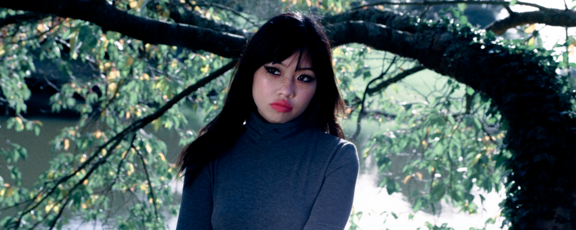 picture of beabadoobee in front of wooded backdrop