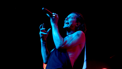 Bush frontman Gavin Rossdale sings into a microphone onstage at a concert