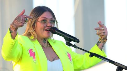 Elle King performs wearing a neon yellow jacket adorned with pink lightning bolts.