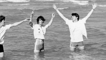The Beatles standing in the ocean