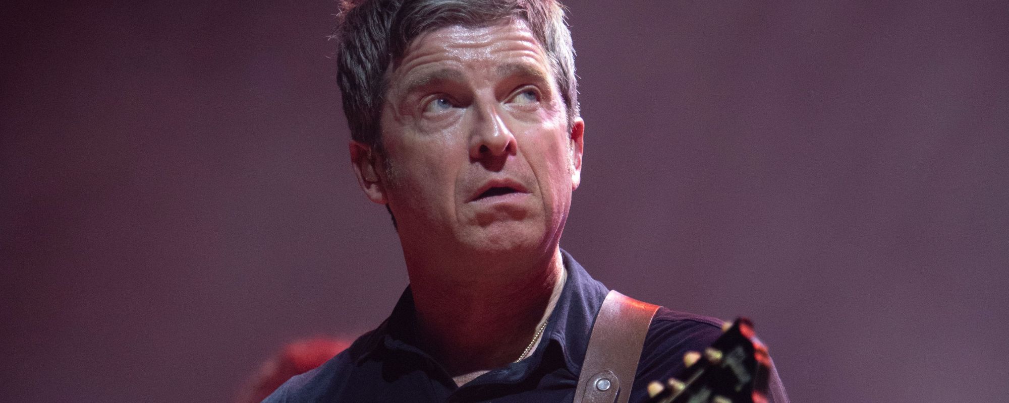 Noel Gallagher performing, looking up