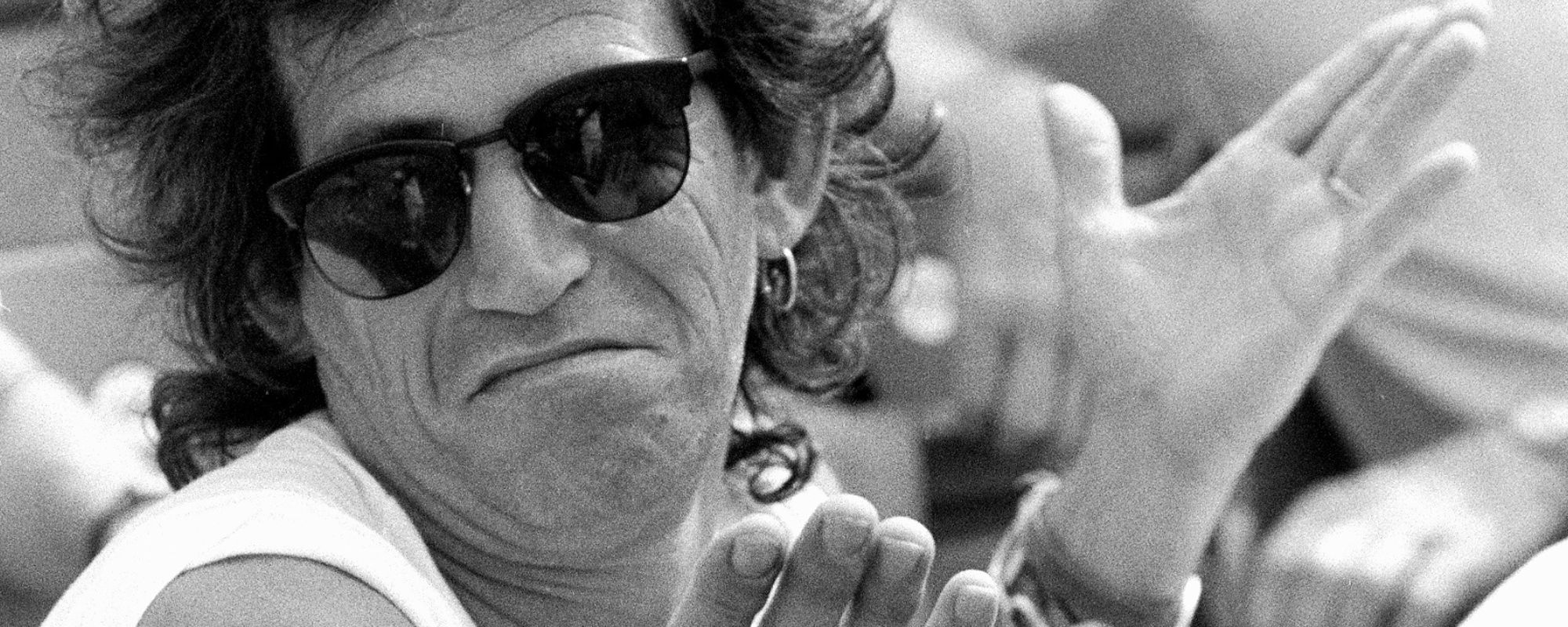 Keith Richards sitting at tennis tournament, one of his jobs before become a rockstar was a tennis ball boy