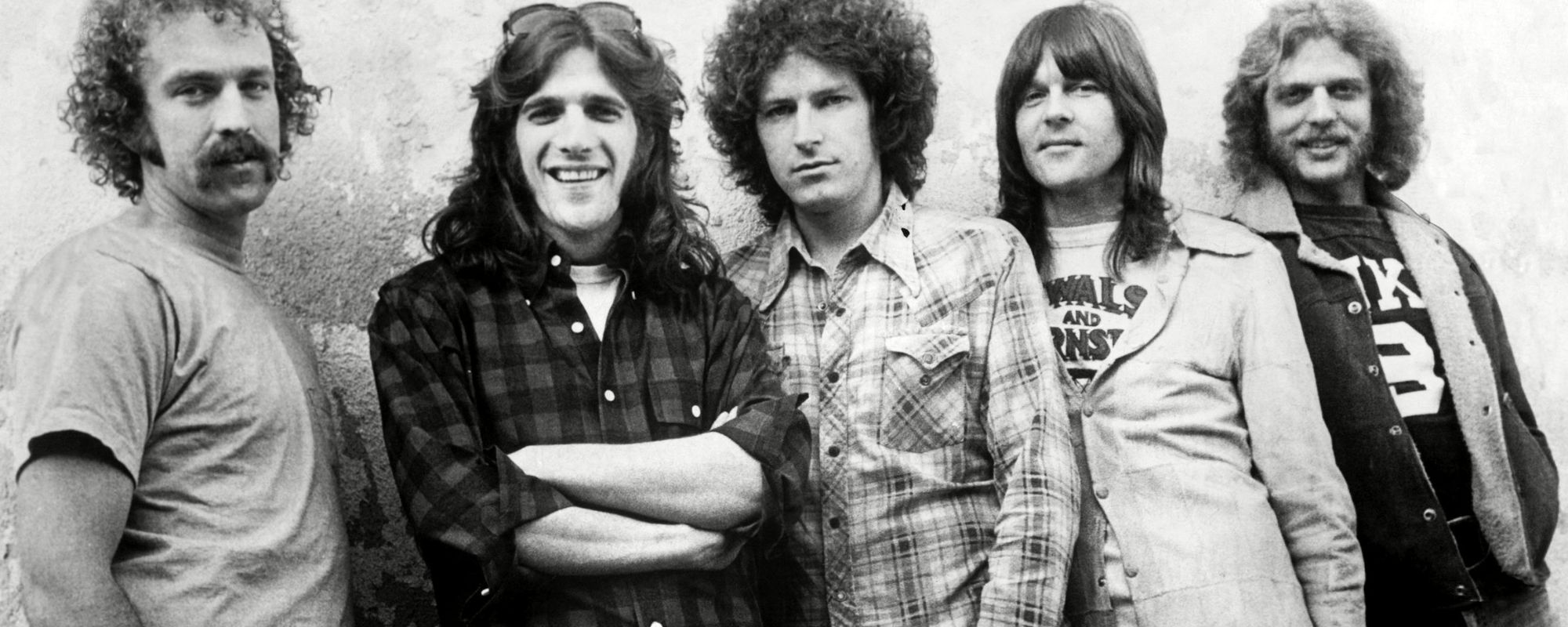 Eagles band posing by wall