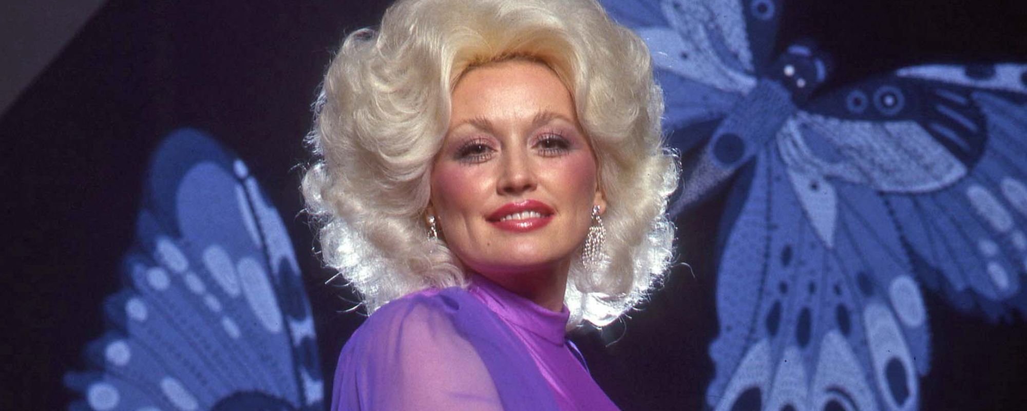 Dolly Parton posing in front of butterflies