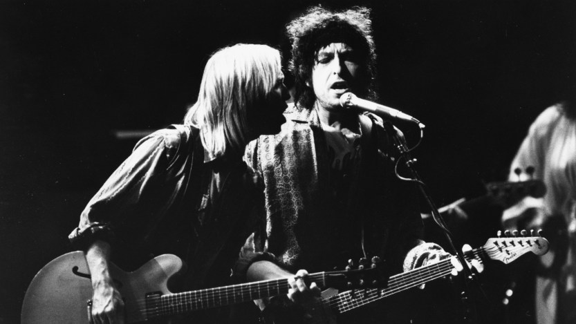 Musicians (L-R) Tom Petty and Bob Dylan, with the band 'Traveling Wilburys', performing on stage, 1987. (Photo by Dave Hogan/Getty Images)